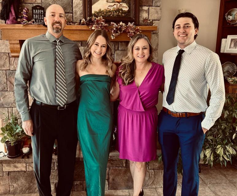 Mrs. Phillips and her family pose in a living room 